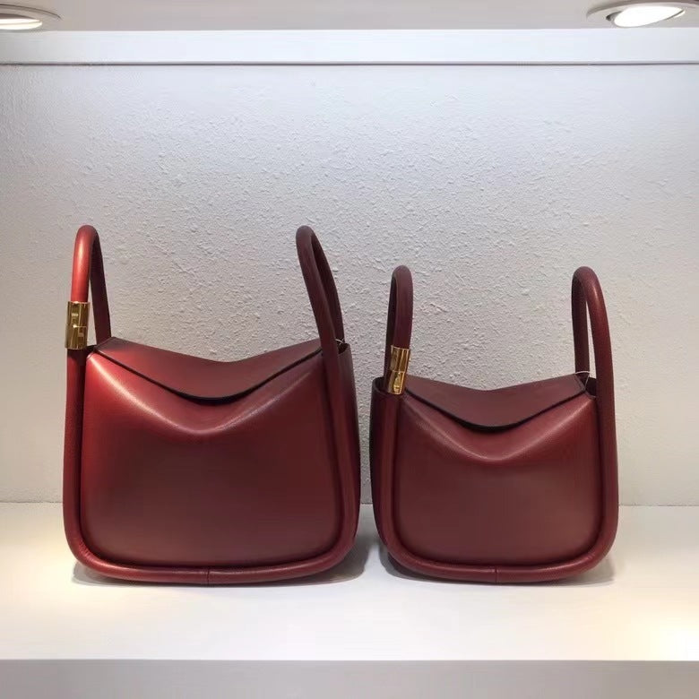 Two red handbags with gold accents on a white background