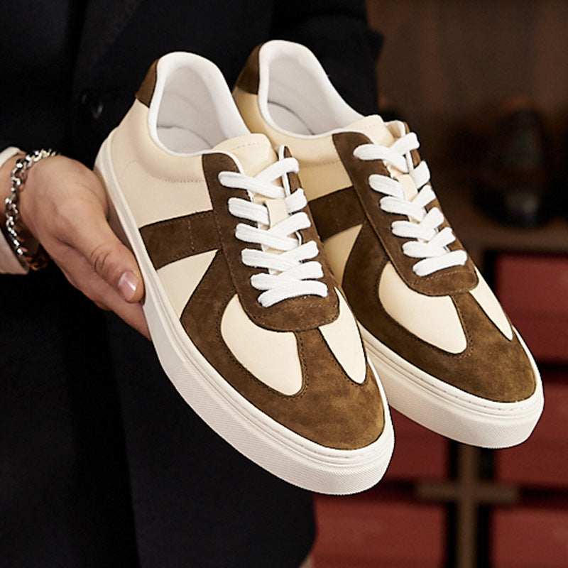Pair of brown and beige sneakers held by a person.