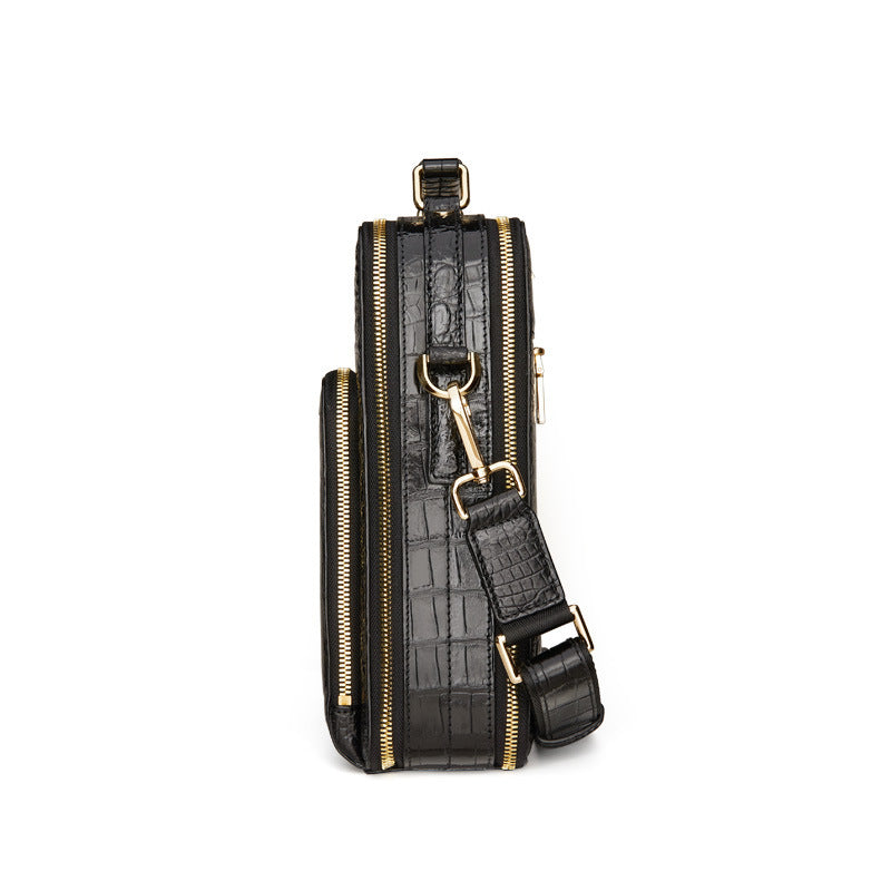 Black leather crossbody bag with gold accents on a white background