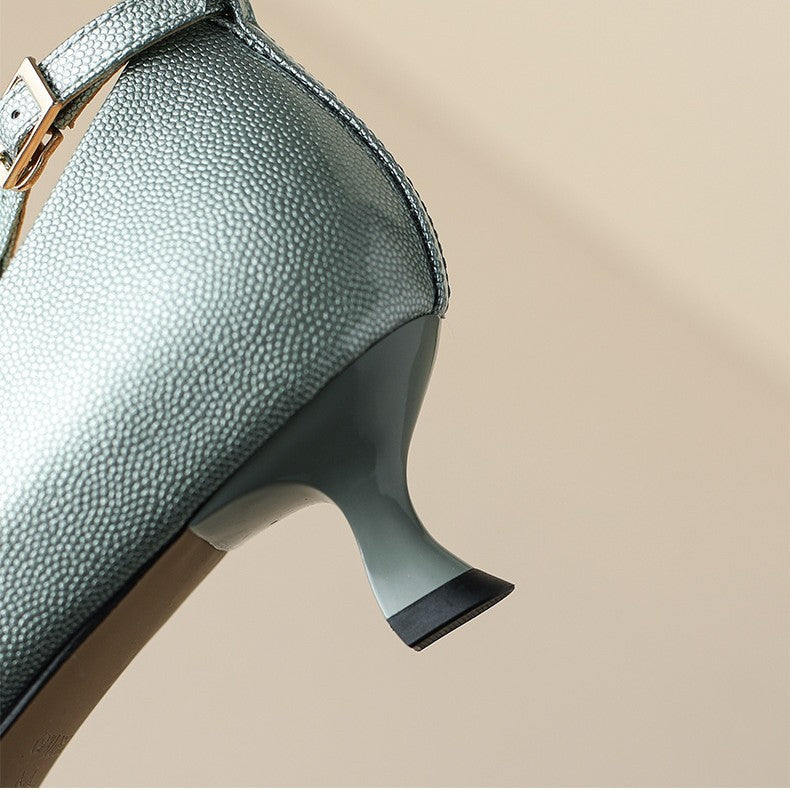 Close-up of a green textured shoe with a beige background