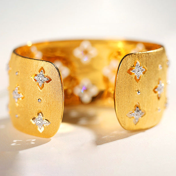Gold bracelet with star designs on a light background