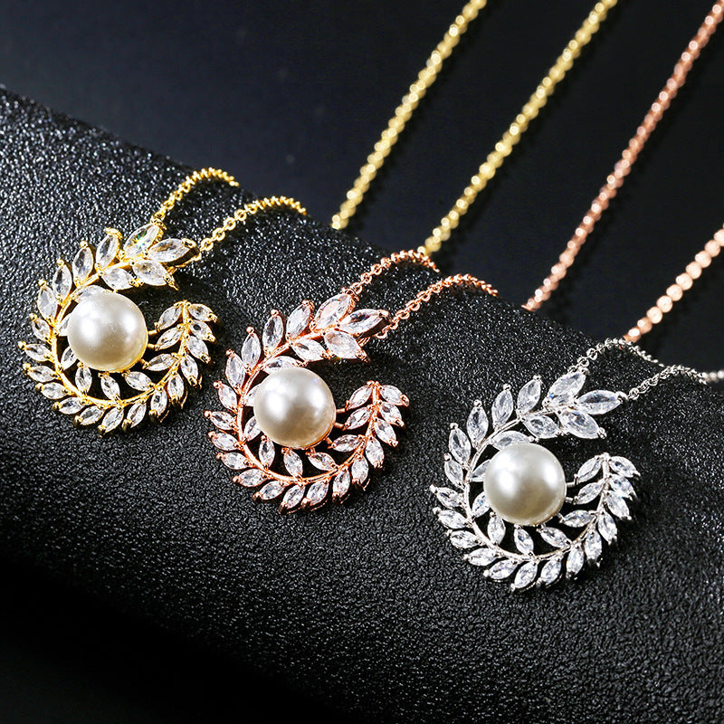 Three pearl necklaces with leaf designs on a black background