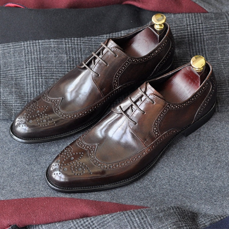 Pair of brown leather dress shoes on a textured fabric surface