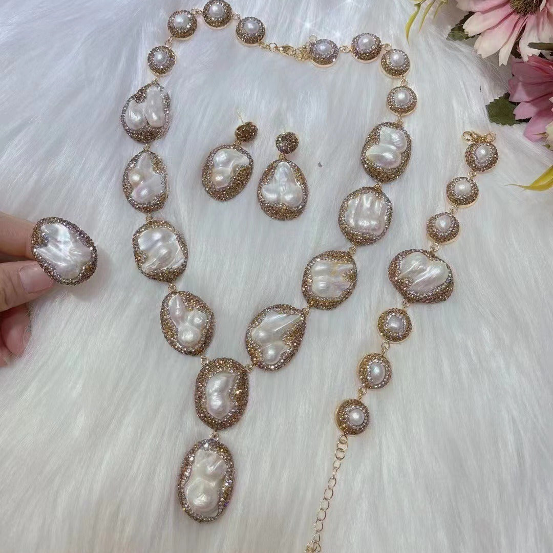 Pearl jewelry set with necklace, earrings, and ring on a white fur background.