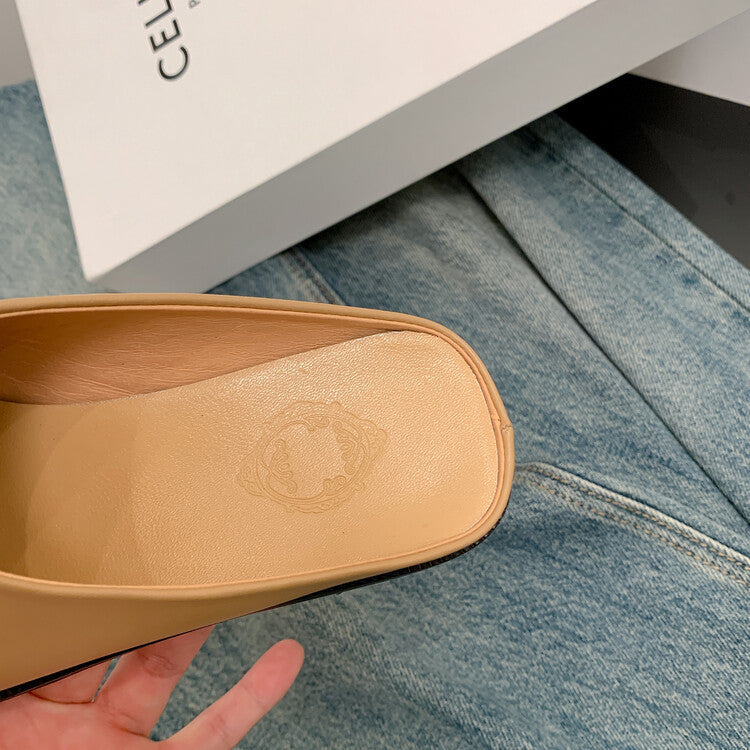 Close-up of a beige shoe sole with a logo on a blue denim surface.