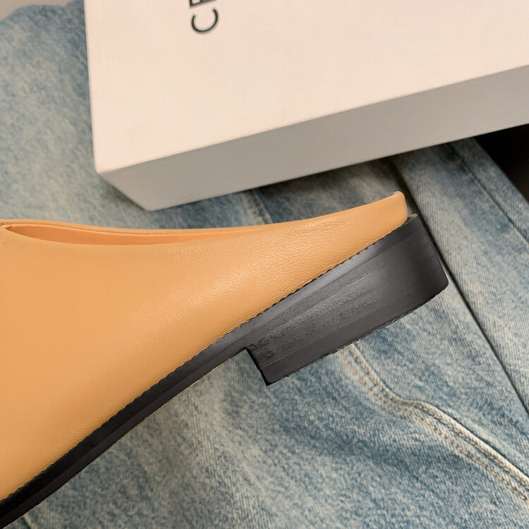 Close-up of a tan shoe with a black sole on a blue denim surface.