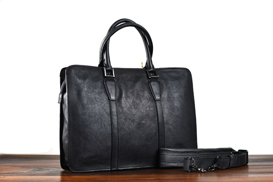 Black leather briefcase on a wooden surface with a white background