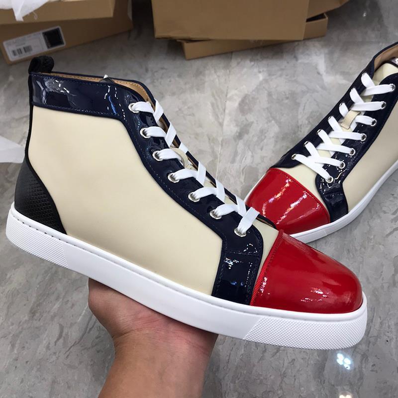 Color-blocked high-top sneakers with beige, navy, and red design held by a hand on a gray surface.
