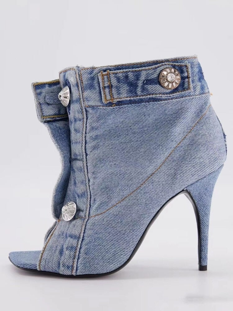 Blue denim high-heeled shoes with peep-toe design on a light gray background