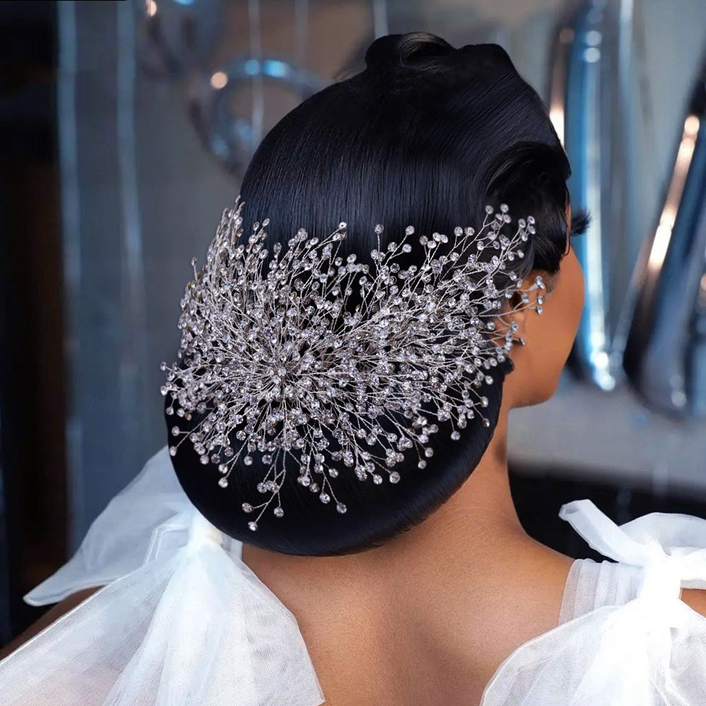 Woman with an elegant updo hairstyle featuring decorative hairpiece.