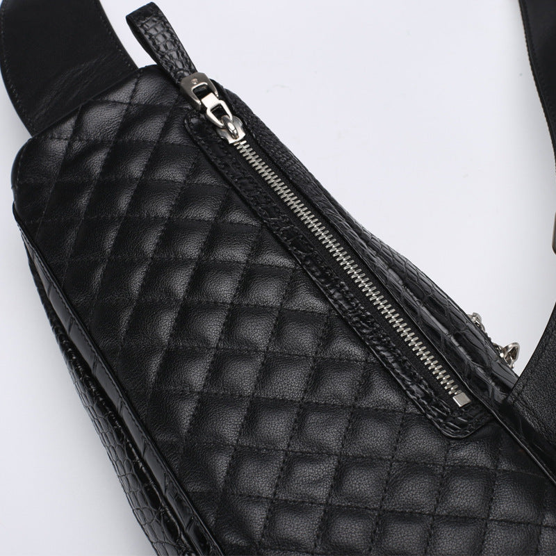 Black quilted bag with a zipper on a white background