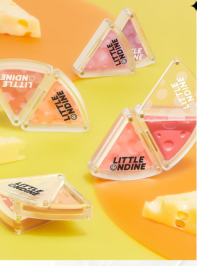 Triangular blushes with 'Little Nudine' branding on a yellow and orange gradient background.