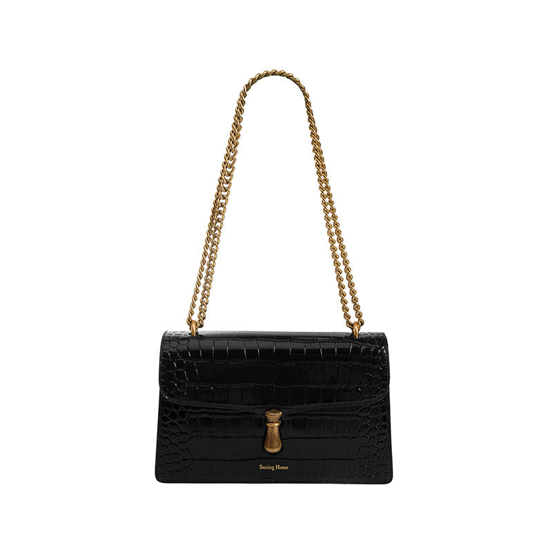 Black handbag with gold chain strap on a white background