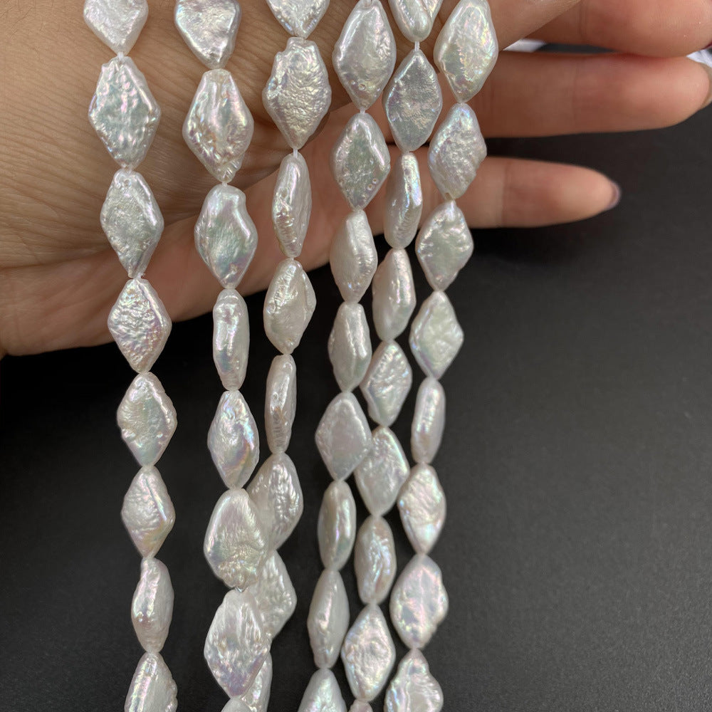 Pearl necklace held by a hand against a dark background