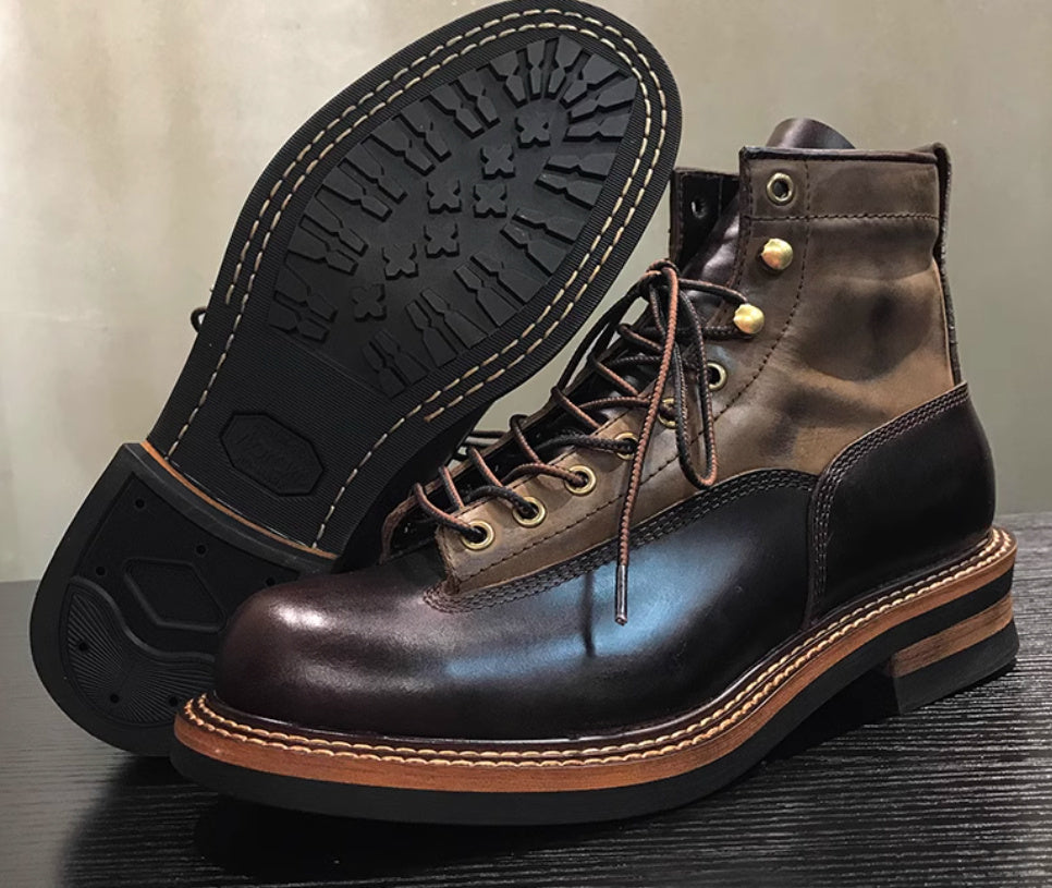 Pair of brown leather boots with black soles on a wooden surface