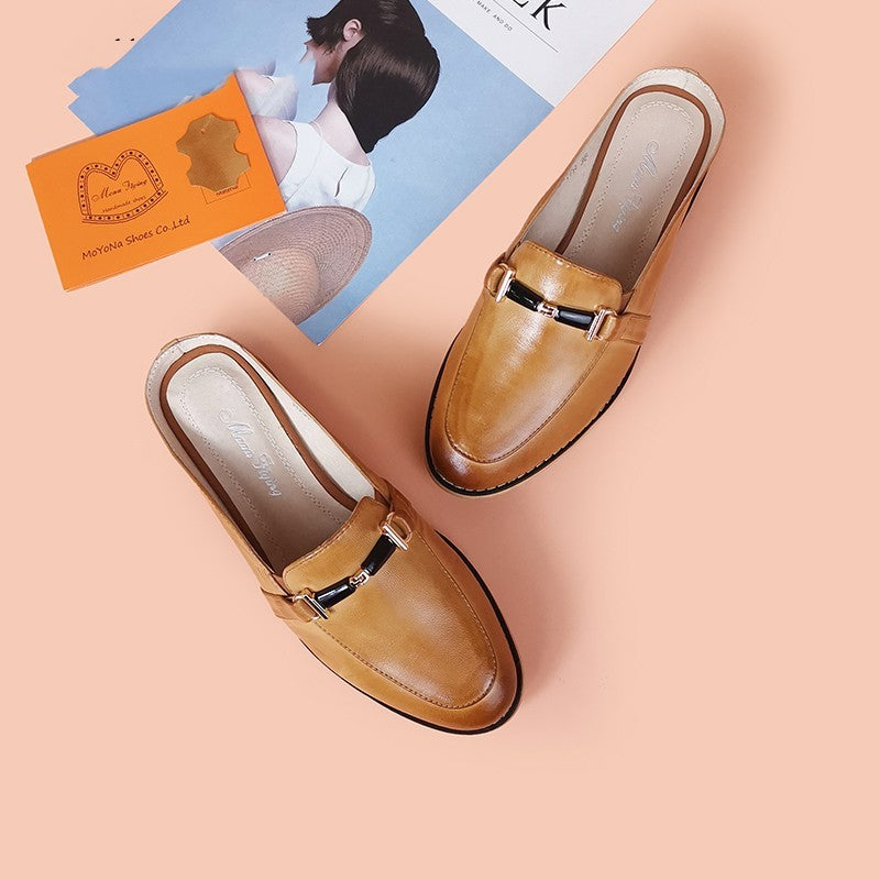 Brown loafers on a peach background with a magazine and card.