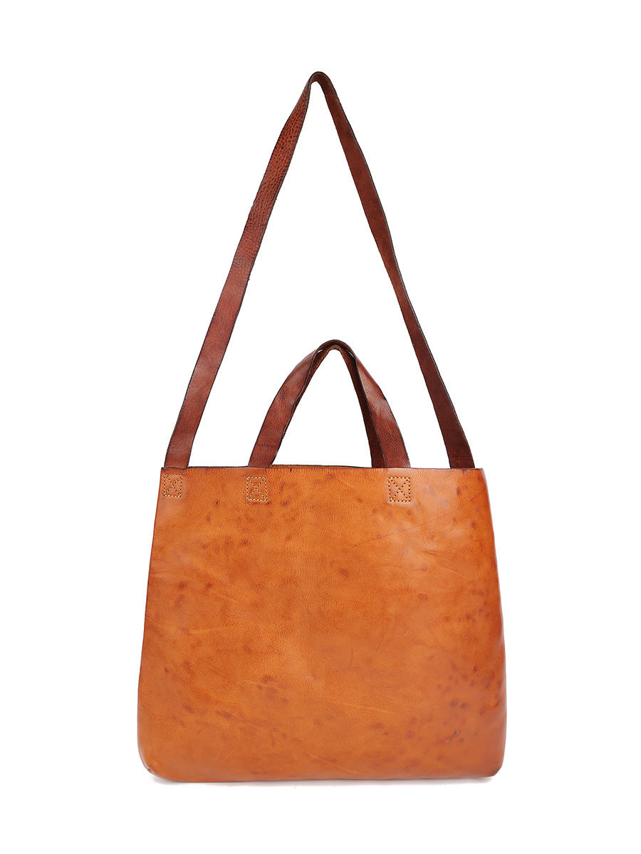 Brown leather handbag with a strap on a white background