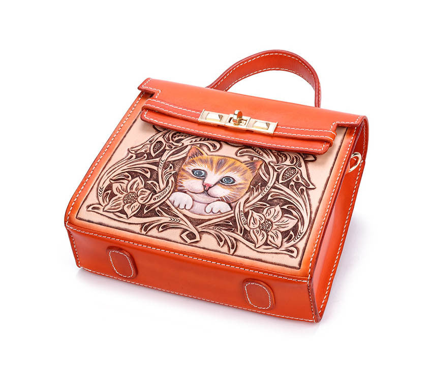 Orange handbag with a cat design on a white background