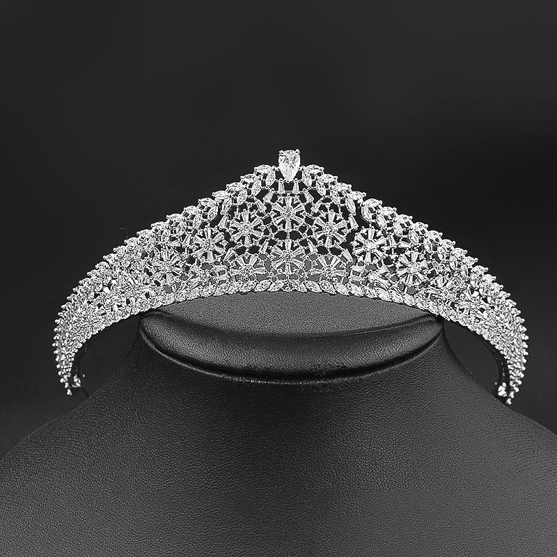 Silver tiara on a black mannequin head against a black background