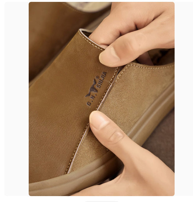 Close-up of a brown leather shoe with a hand touching it, featuring a brand logo.