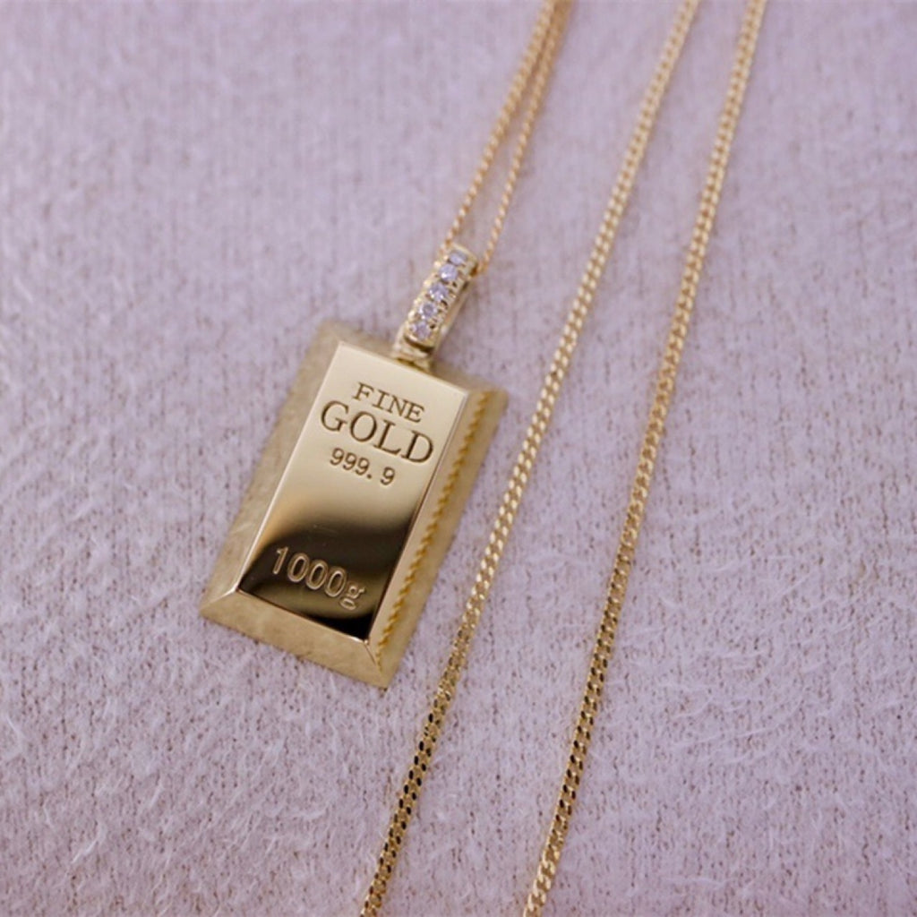 Gold bar pendant necklace on a light purple background