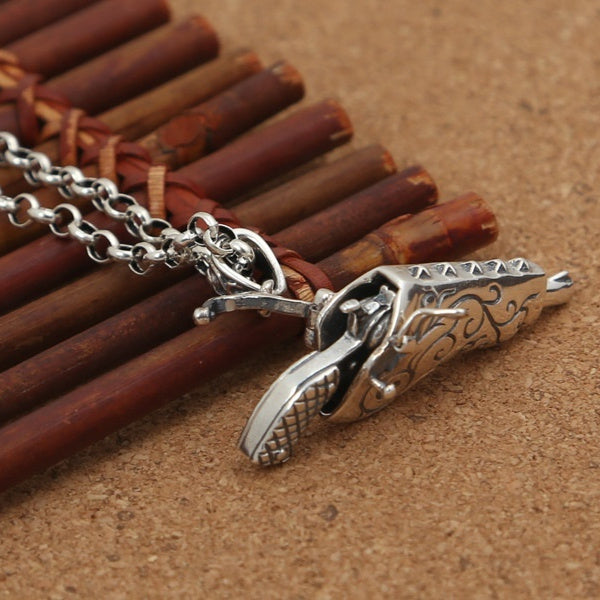 Silver pendant with intricate design on a wooden background