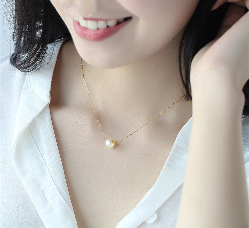 Pearl necklace worn by a person with a white shirt