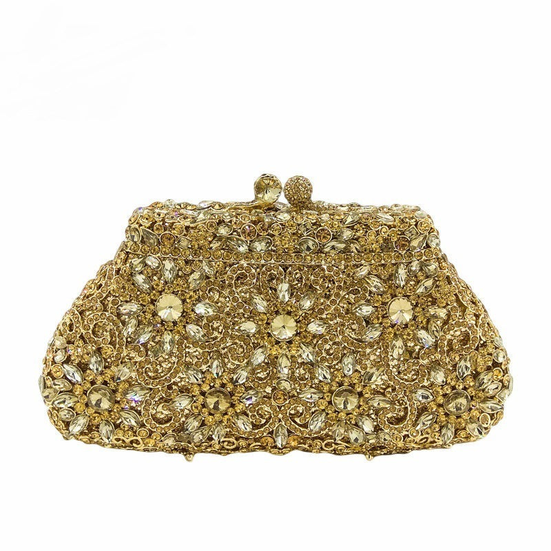 Gold clutch bag with intricate gemstone detailing on a white background