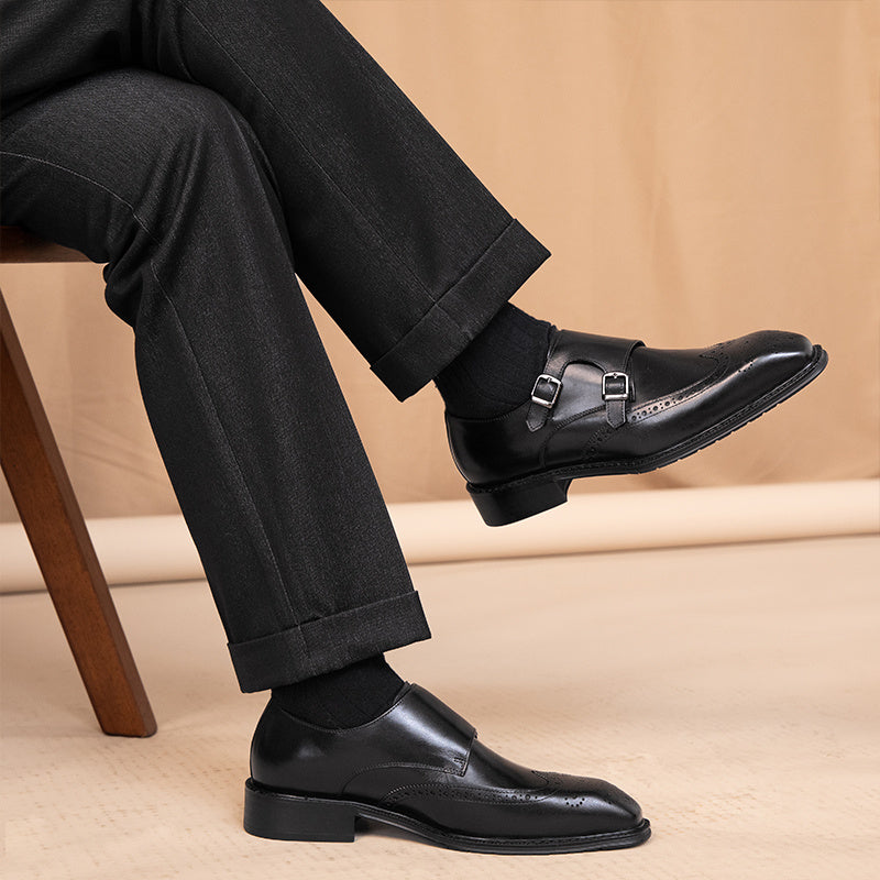 Person wearing black dress shoes and pants on a beige background