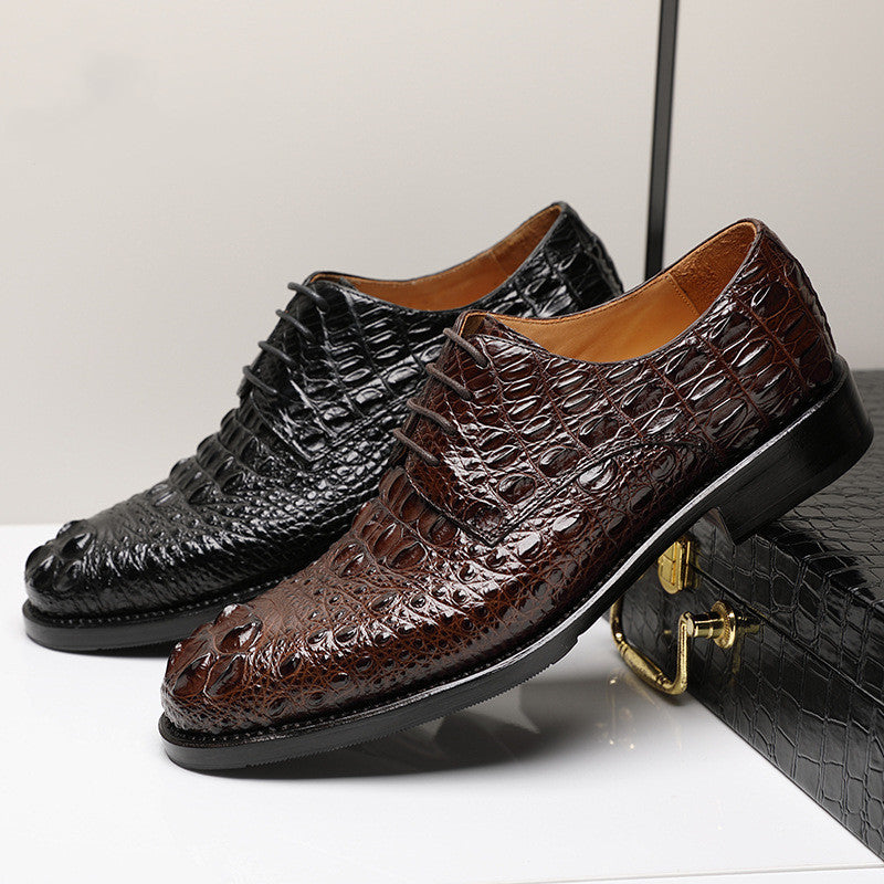 Two pairs of crocodile-patterned dress shoes on a light gray background
