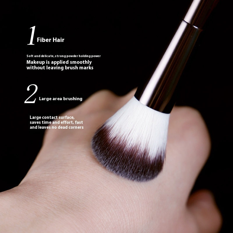 Makeup brush with fiber hair on a hand against a black background