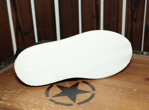 White shoe sole with a star logo on a wooden surface