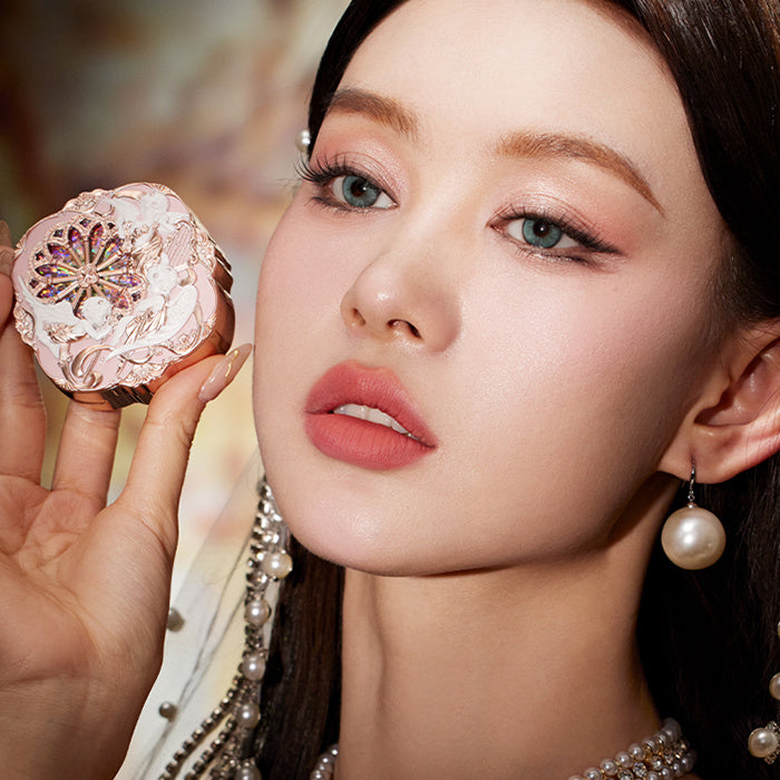 Woman holding a decorative compact mirror with intricate design