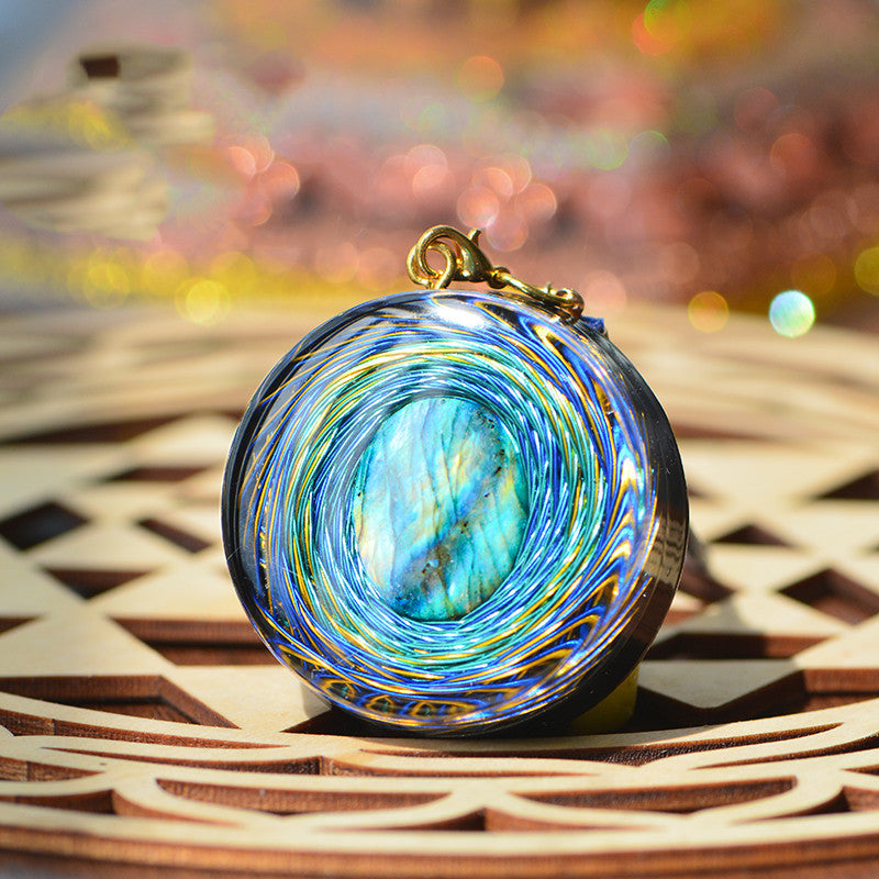 Multicolored stone pendant on a wooden surface with a blurred colorful background
