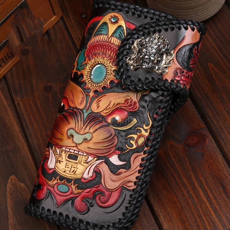 Decorative leather wallet with intricate designs on a wooden surface
