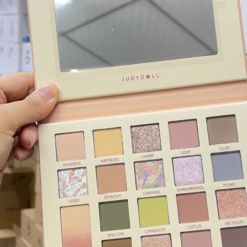 Judydoll eyeshadow palette held by a hand with a blurred background