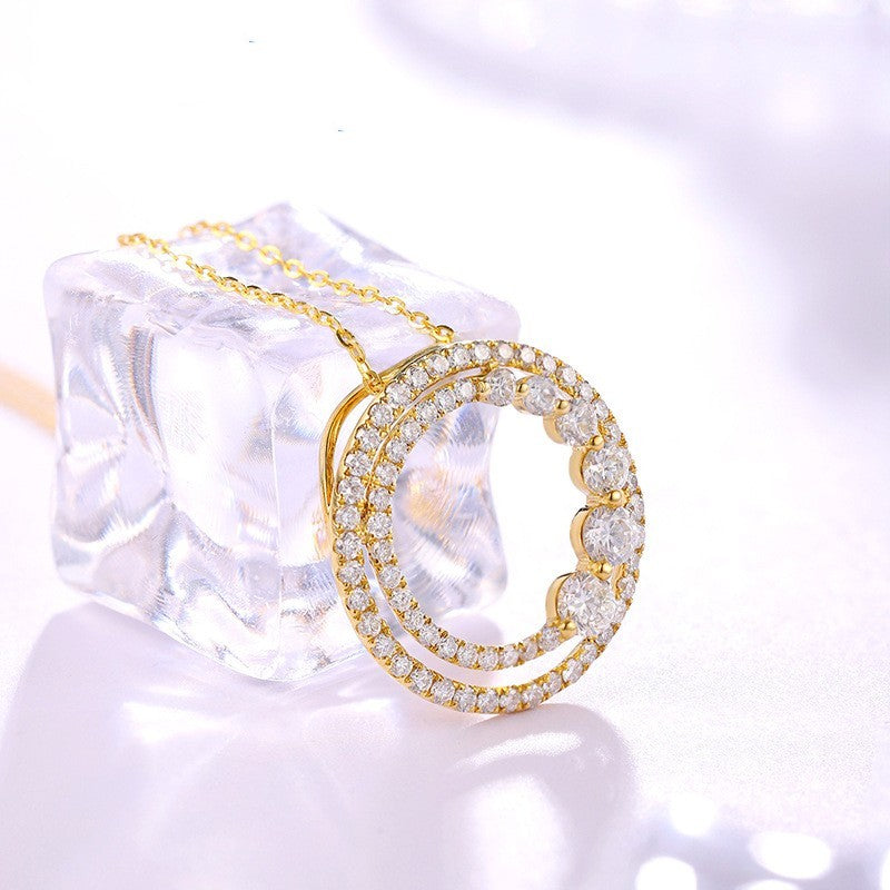 Gold necklace with circular pendant on a white background