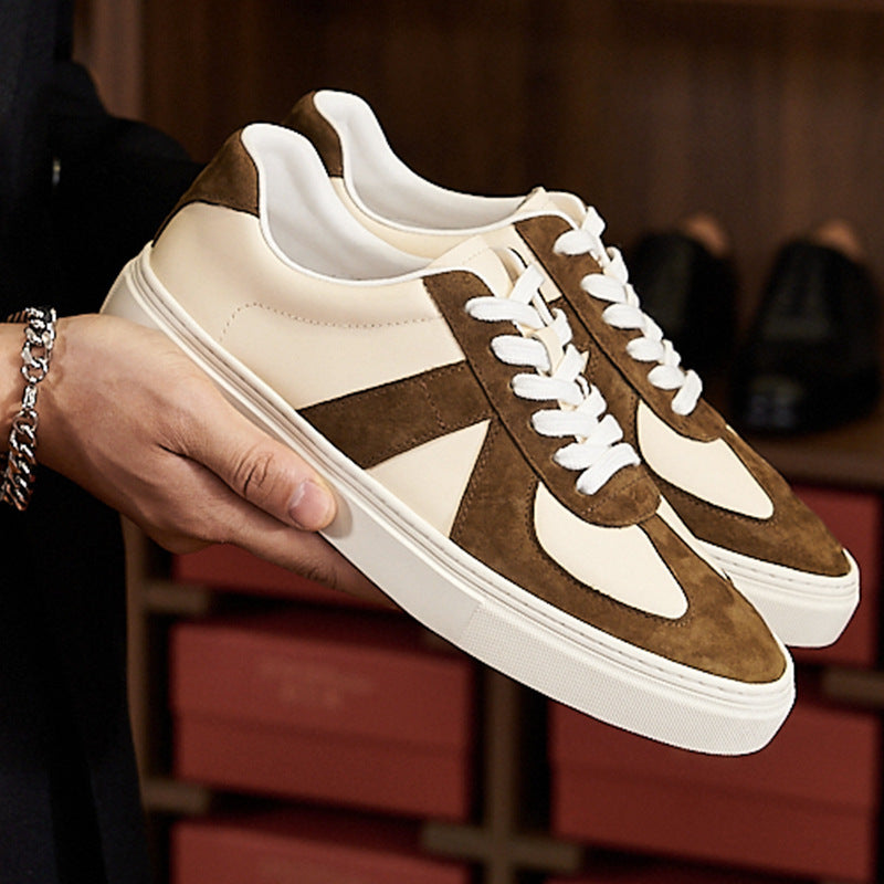 Brown and beige sneakers held by a hand with a blurred background