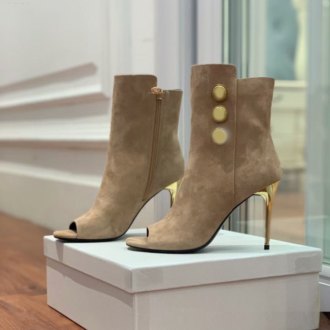 Pair of beige high-heeled boots with gold buttons on a white box.