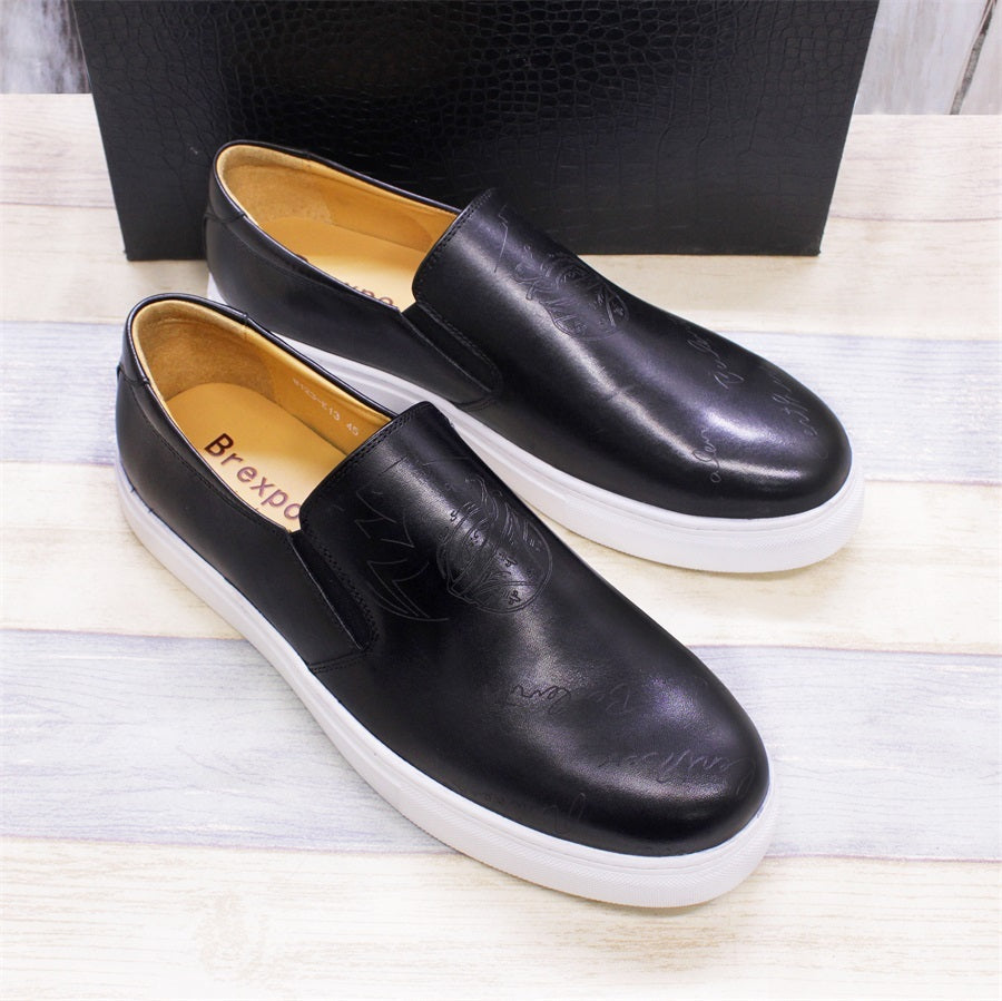Black leather shoes with white soles on a light wooden surface
