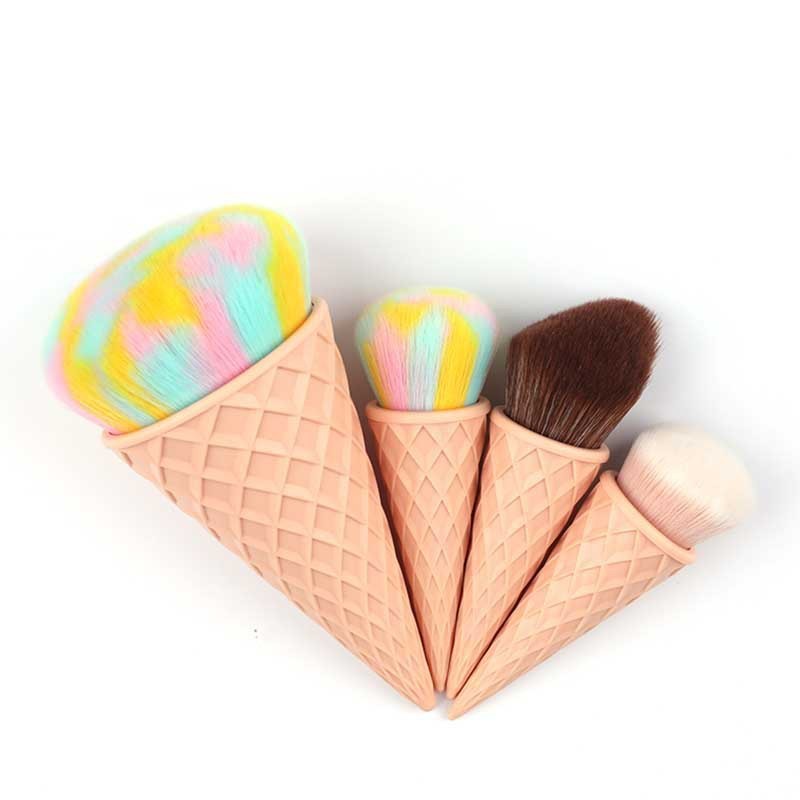 Makeup brushes shaped like ice cream cones with colorful toppings on a white background