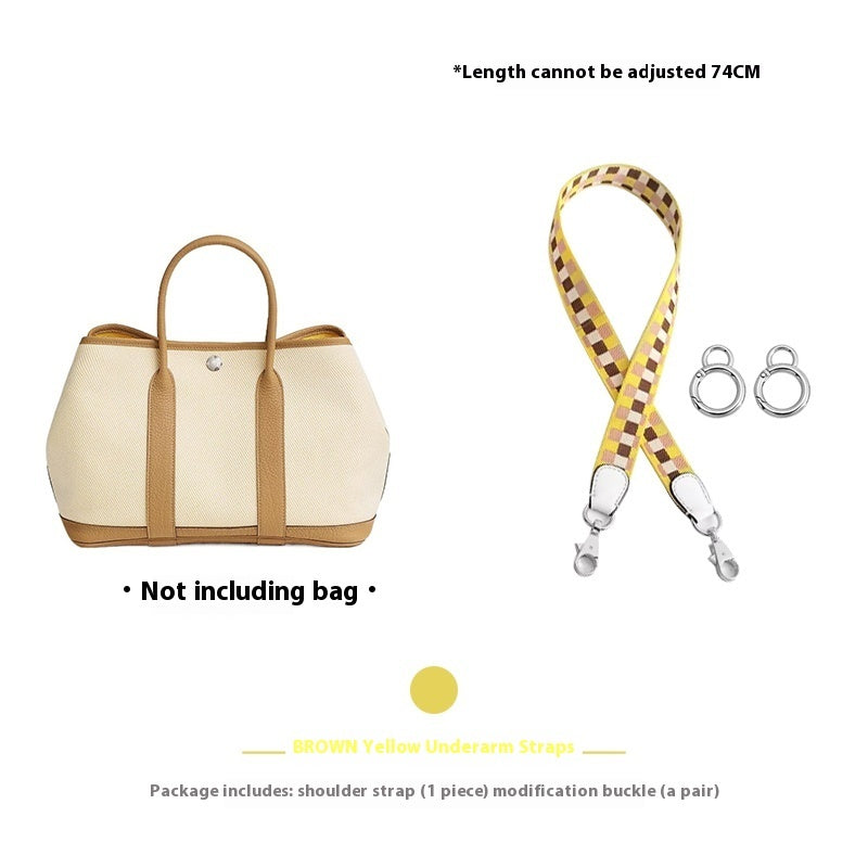 Beige handbag with a yellow and brown checkered strap and accessories on a white background.