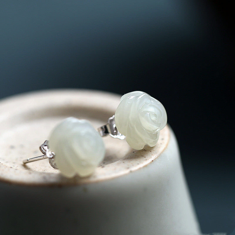 Pair of light green jade earrings on a dark background