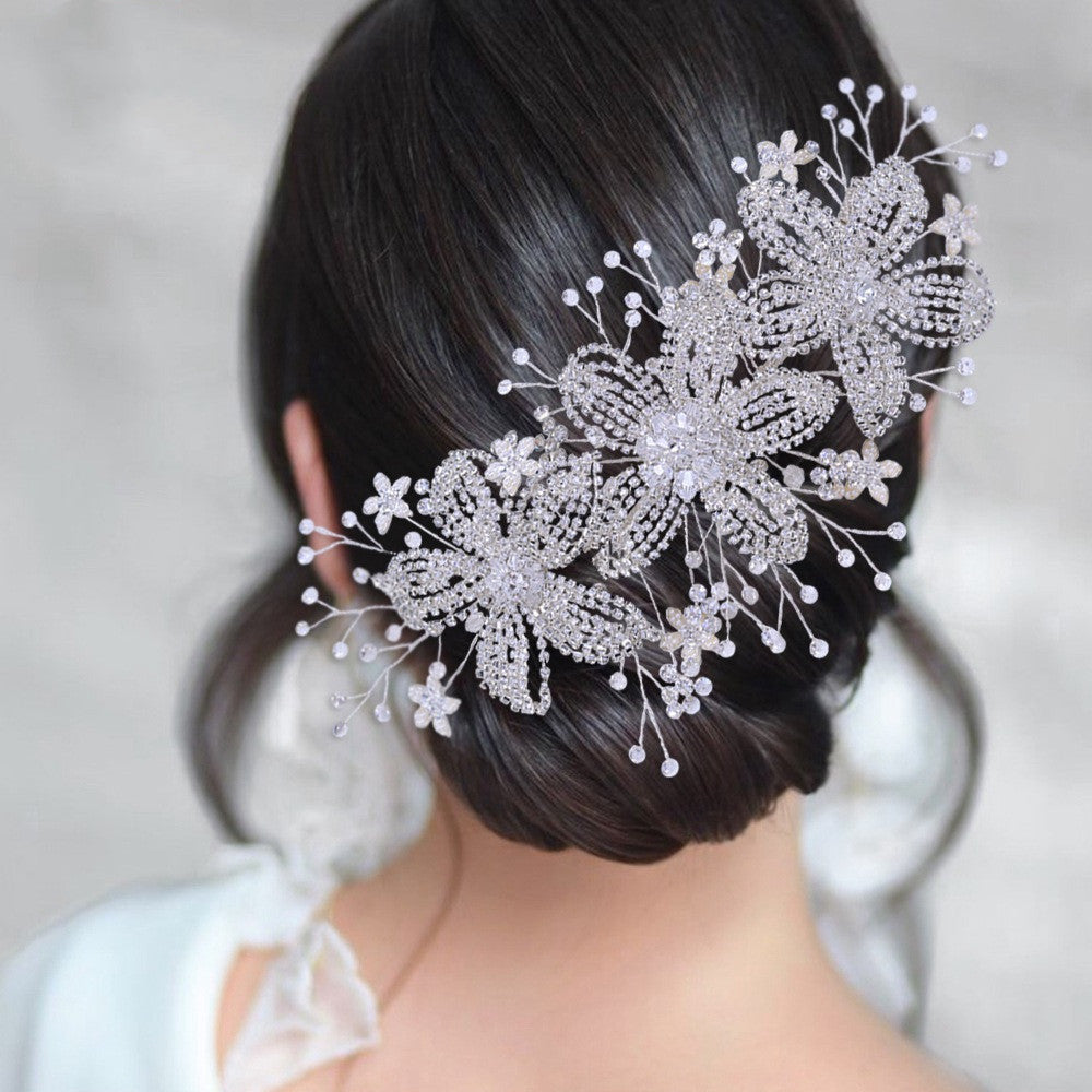 Bridal hair accessory with floral design on a person with dark hair.