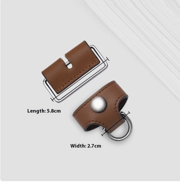 Brown leather belt buckle with silver hardware on a light gray background