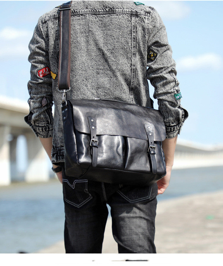 Person wearing a black leather shoulder bag outdoors