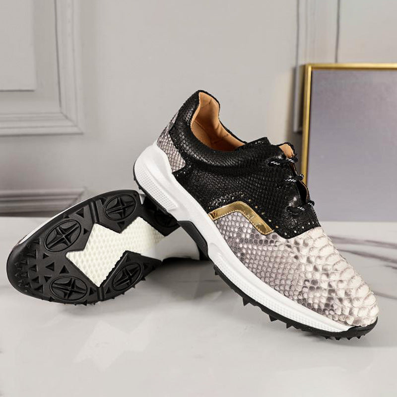 Black and white sneakers with snake skin pattern on a light gray surface.