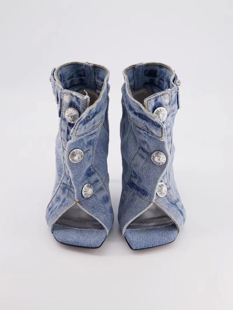 Denim high-heeled shoes with crystal embellishments on a white background