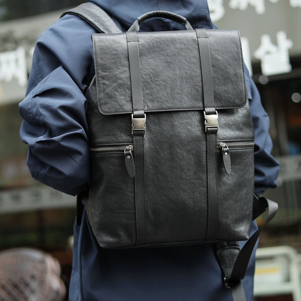 Person wearing a dark gray backpack with a blurred background