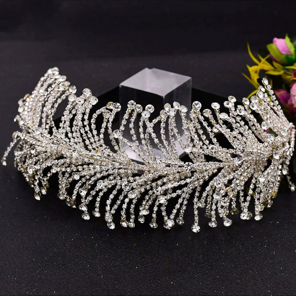Silver tiara with intricate design on a black background